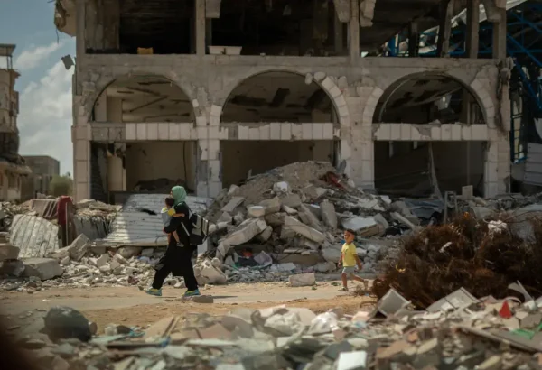 una mujer lleva a su hijo de vuelta a casa entre los escombros. Gaza, Palestina.