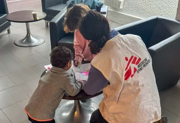 Dos niños iraníes con su madre en Calais. MSF les dio cobijo. Aquí juegan con una trabajadora de MSF. © Mohammad Ghannam / MSF