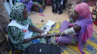 Una partera de MSF toma la presión arterial de una mujer embarazada en un campo para personas desplazadas internas en Ansongo, Mali.