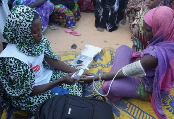 Una partera de MSF toma la presión arterial de una mujer embarazada en un campo para personas desplazadas internas en Ansongo, Mali.