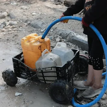 Un niño palestino recoge agua en la ciudad de Beit Lahia, al norte de la Franja de Gaza. Palestina 2025.
