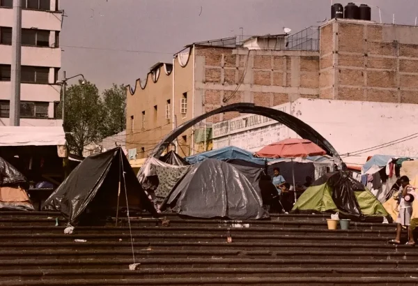 Personas migrantes del continente americano y extracontinentales han construido un refugio temporal en a Plaza de la Soledad en Ciudad de México.