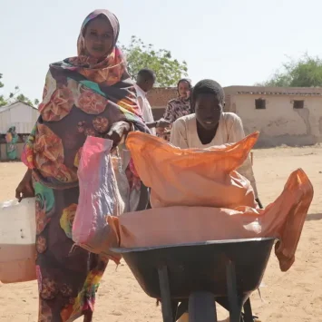 Una madre y su hijo reciben una canasta de alimentos en el campo de personas internamente desplazadas de Autash. Sudán.