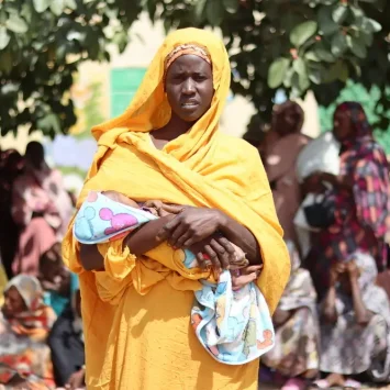 Ikhlas Musa Ramadan, una de las muchas madres admitidas en el programa de MSF para cuidar a mujeres lactantes y embarazadas que sufren de desnutrición severa, hace fila esperando su turno para recibir la cesta de alimentos.
