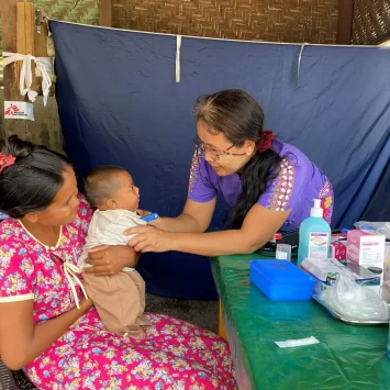 Una integrante de MSF revisando a un bebé en una clínica movil de la organización en Mandalay, donde respondió tras el terremoto en Myanmar.