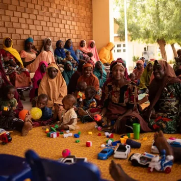Mujeres, niñas y niños asisten a las sesiones sobre la promoción de la salud nutricional en el centro de alimentación para pacientes hospitalizados de la ciudad de Katsina, Nigeria.