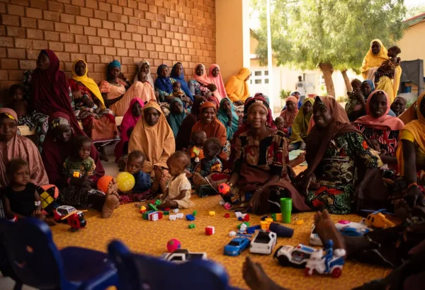 Mujeres, niñas y niños asisten a las sesiones sobre la promoción de la salud nutricional en el centro de alimentación para pacientes hospitalizados de la ciudad de Katsina, Nigeria.