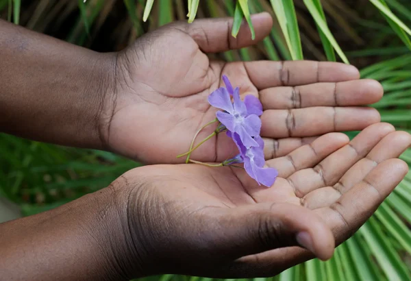 "La flor más grande es para mi hija Edvige: me gustaría volver a verla". Veronique lleva un pañuelo blanco en la cabeza con bordados dorados, se ve elegante.
