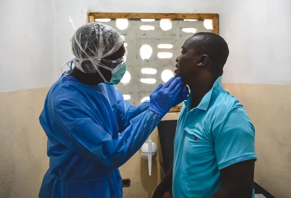 George Kamara, oficial de salud comunitaria de MSF, examina a un paciente dentro del centro de tratamiento mpox en la ciudad de Calaba, Freetown, Sierra Leona, junio de 2025.