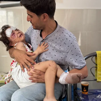 Julia, de 4 años, es sostenida por su padre Ahmed después de resultar herida en un ataque aéreo en su casa en la ciudad de Gaza.