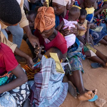 Andre Marcos, promotor de salud de MSF, ayuda en el triaje de niños en la sala de espera del centro de reasentamiento temporal de Micone, en la ciudad de Chiure, al sur de Cabo Delgado.