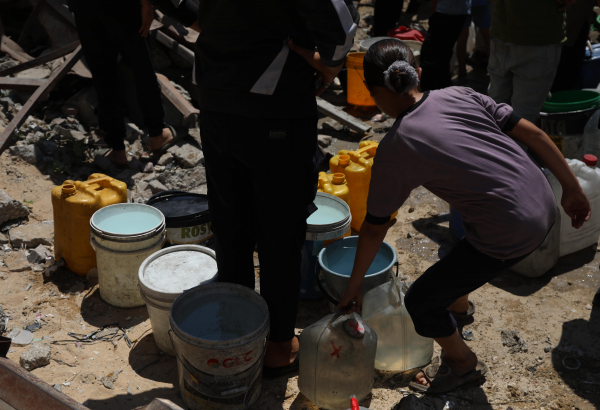 Una niña recolectando agua en la Franja de Gaza.