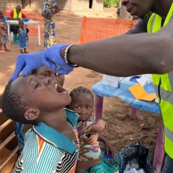 Un niño recibe la vacuna oral contra la poliomielitis durante una sesión de vacunación dirigida por MSF en Mala, donde las iniciativas de divulgación se centran en las familias desfavorecidas.