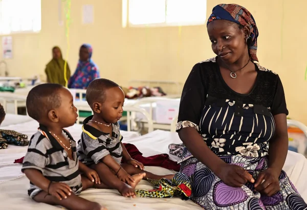 Binta Abdulraziqu junto a sus hijos gemelos, quienes fueron ingresados ​​por desnutrición aguda grave en el centro de nutrición terapéutica para pacientes hospitalizados de Maiyama. Estado de Kebbi, Nigeria, agosto de 2025.