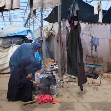 Una mujer desplazada y su hija preparan la comida en Al Mawasi, Jan Yunis. Octubre, 2025