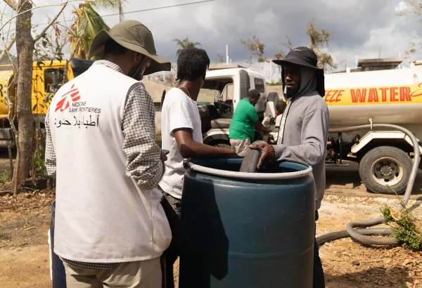 Lal Badshah, responsable de agua y saneamiento supervisa el llenado de un tanque de agua de 200 litros en la parroquia de Santa Isabel. La parroquia aún carece de electricidad y la infraestructura hídrica sigue interrumpida.