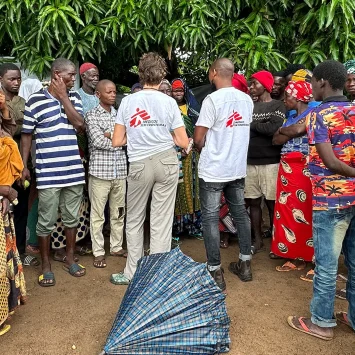 El equipo de MSF conversa con un grupo de personas desplazadas que esperan fuera de una clínica móvil de MSF en Alua Velha, provincia de Nampula, Mozambique.