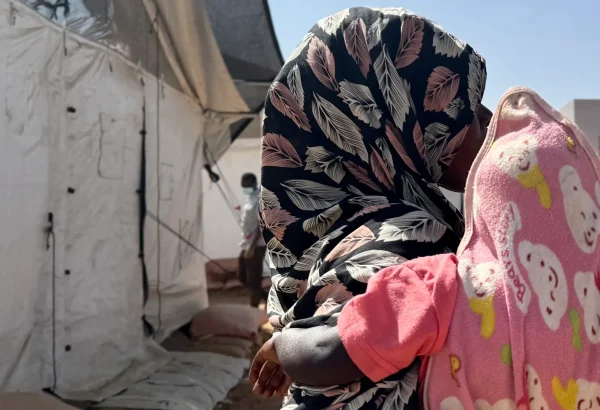 Amina* abraza a un niño frente a un refugio improvisado en Tawila. Mientras huía de El Fasher con sus hijos, fue violada por hombres armados. Estado de Darfur del Norte, Sudán, febrero de 2026. *Se ha utilizado un seudónimo para proteger su identidad.