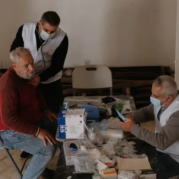 Un médico de MSF revisa el pecho de un hombre desplazado mientras un enfermero registra sus constantes vitales. Líbano, Beirut, 2026.