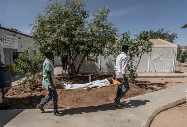 Dos trabajadores médicos de MSF transportan a un niño pequeño en una camilla desde el quirófano hasta la unidad de cuidados intensivos del Hospital París gestionado por MSF en Tawila.